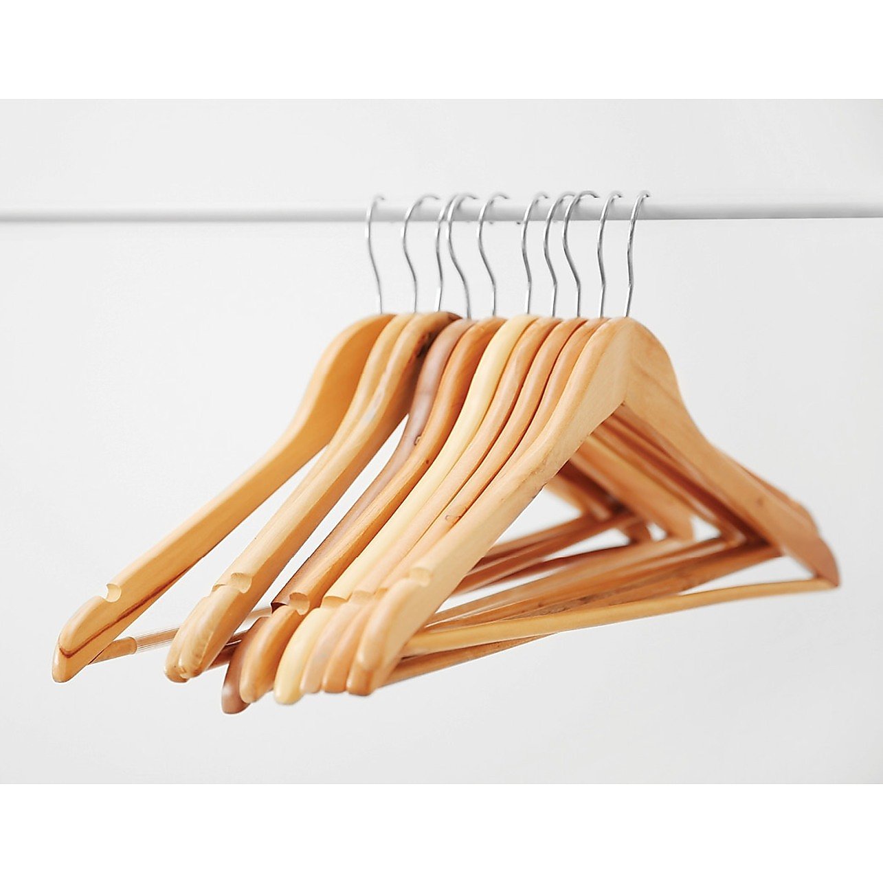 Set of 120 wooden clothes hangers by Magenta Danae, displaying coat, pant, and suit hangers on a wardrobe rack.
