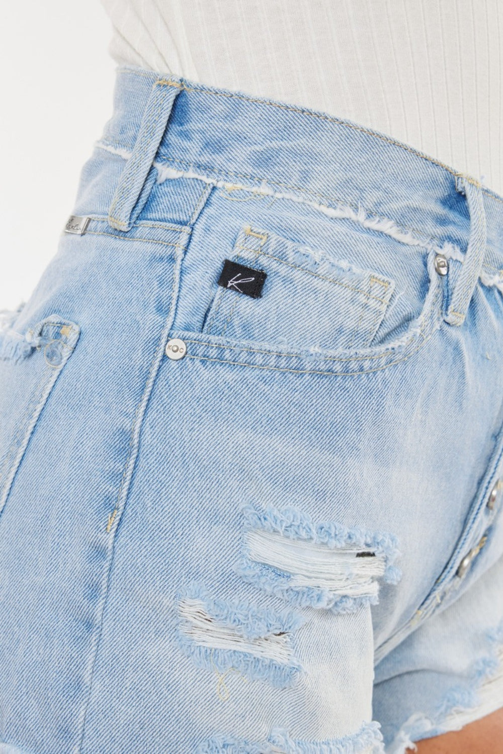 Jade Icarus automotive model with distressed denim shorts featuring button fly design, displayed on a clean background.
