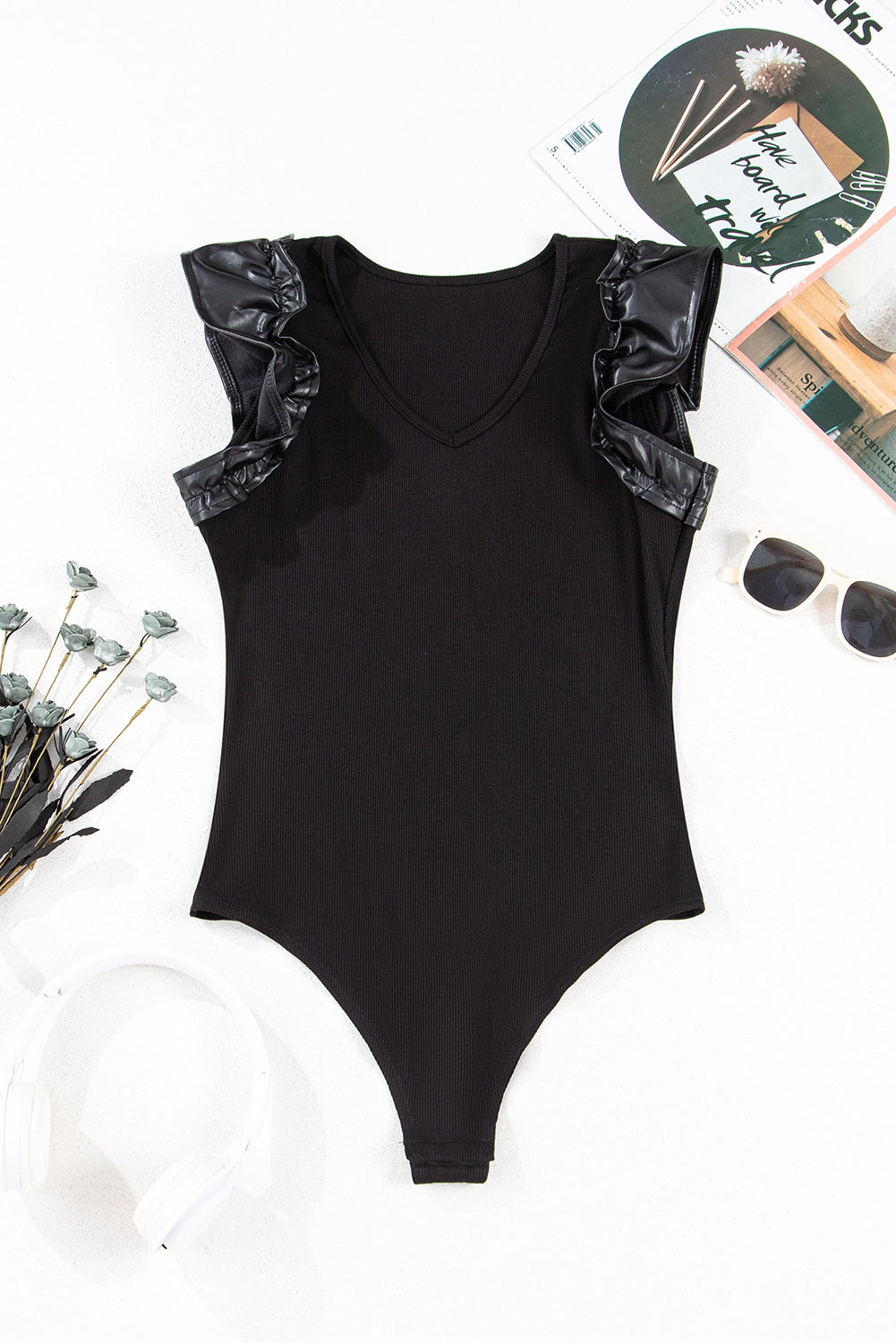 Solid ribbed leatherette bodysuit with ruffle sleeves from Byzantium Bay, shown in a close-up of the textured fabric and stylish design.