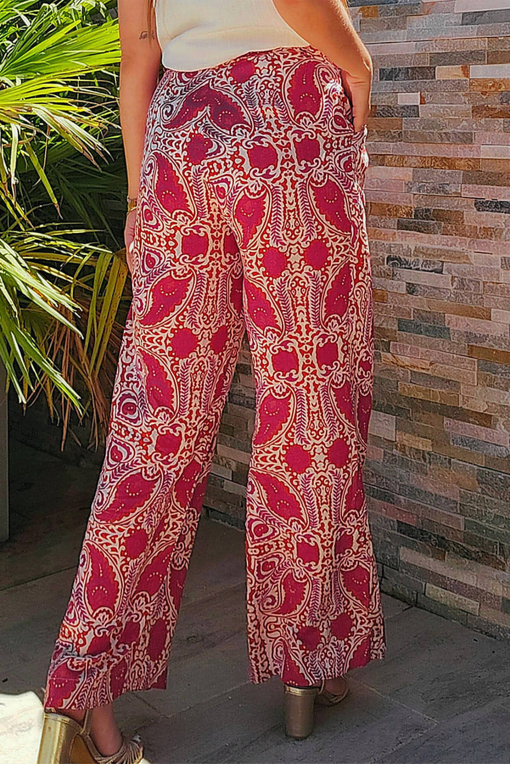 Red paisley printed high waist straight leg pants by Carmine Juneberry, featuring button details and a stylish, relaxed fit.