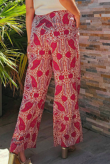 Red paisley printed high waist straight leg pants by Carmine Juneberry, featuring button details and a stylish, relaxed fit.