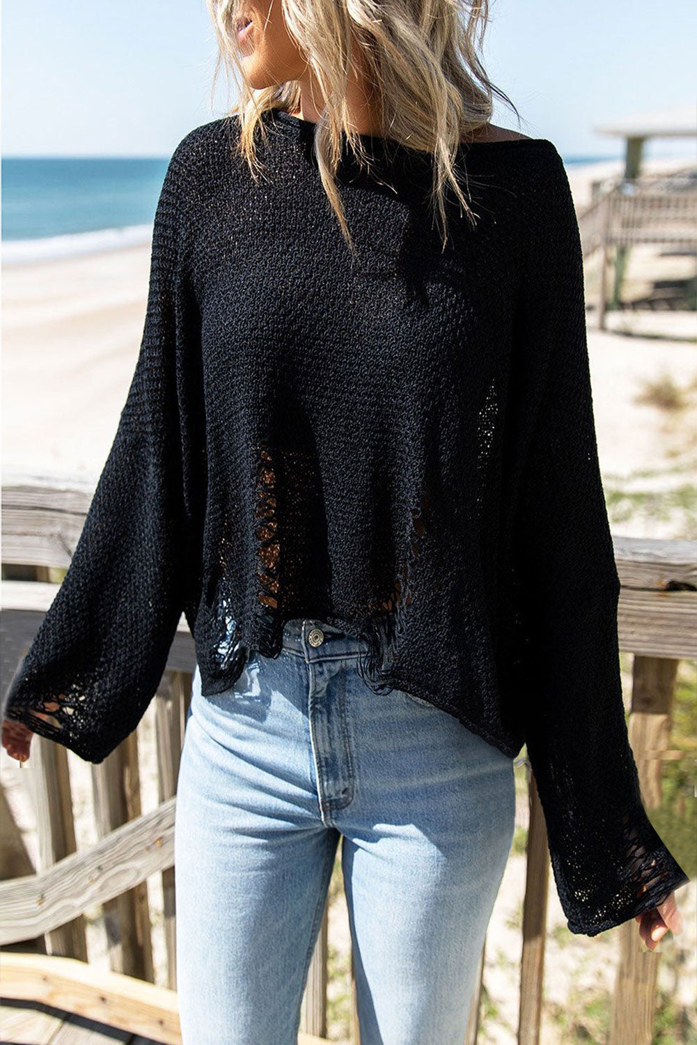 Black distressed boxy fit crop knit sweater from Harlequin Daisy, featuring a casual, cozy style with distressed details.