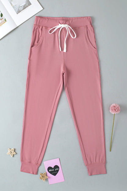 Pink drawstring waist joggers with side pockets, activewear by Carmine Juneberry, perfect for comfortable workouts and casual wear.