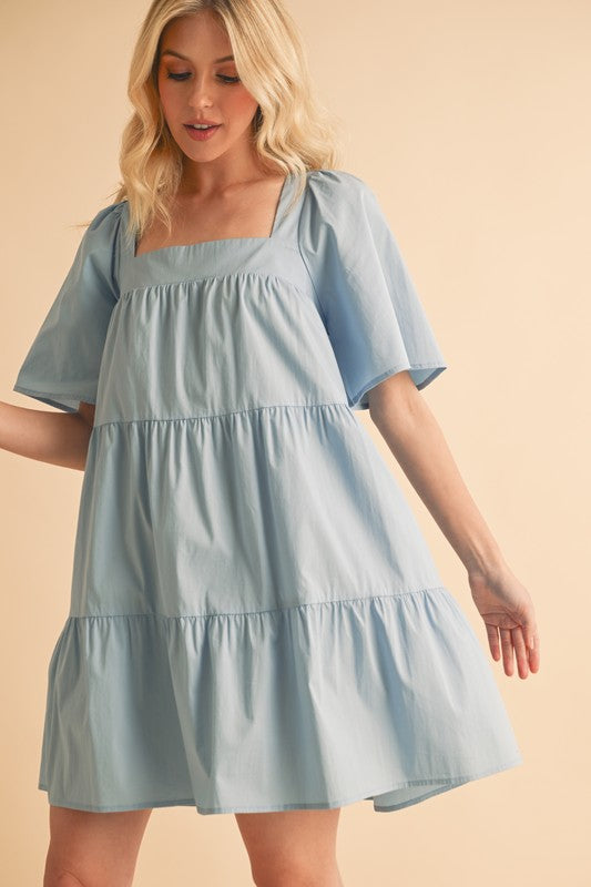Automotive Jade Icarus Aemi + Co square neck half sleeve tiered dress, shown in a stylish fashion image
