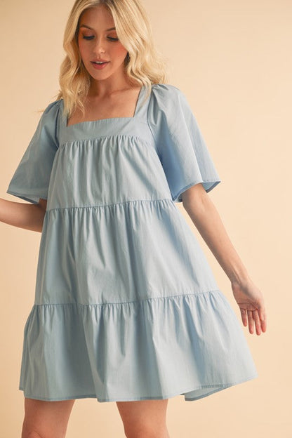 Automotive Jade Icarus Aemi + Co square neck half sleeve tiered dress, shown in a stylish fashion image
