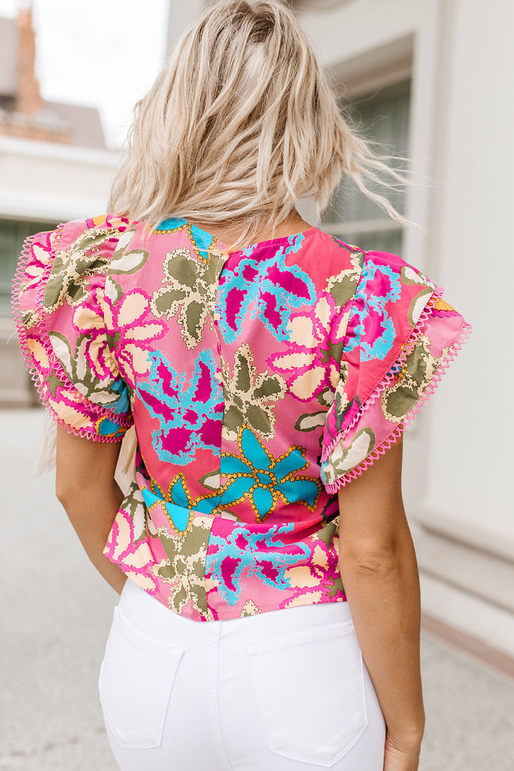 Multicolor floral print ruffle sleeve blouse by Carmine Juneberry, featuring vibrant colors and a stylish trim detail.
