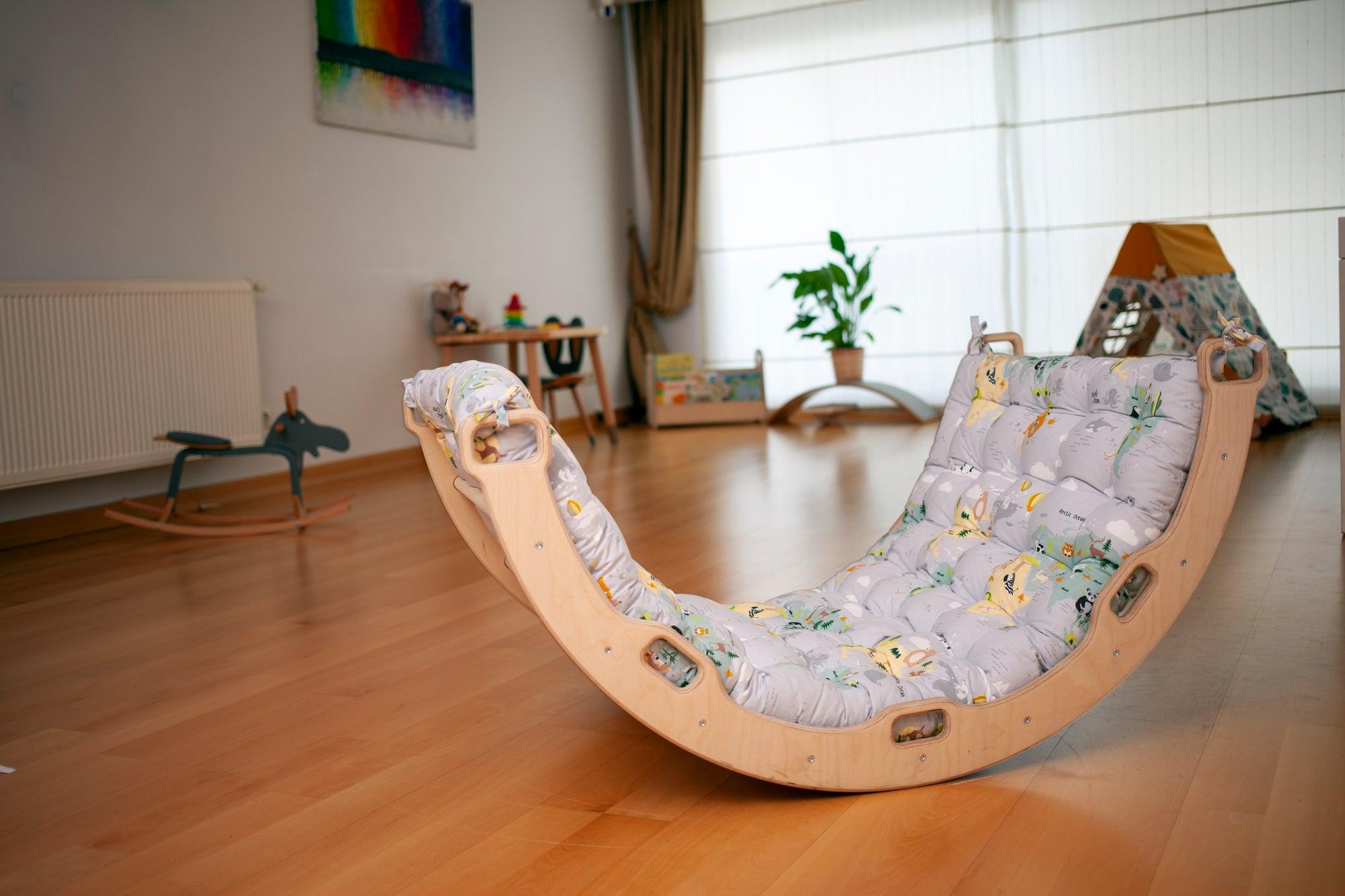 Red Oceanus climbing arch with a colorful map pattern pillow, designed as playful furniture for children&