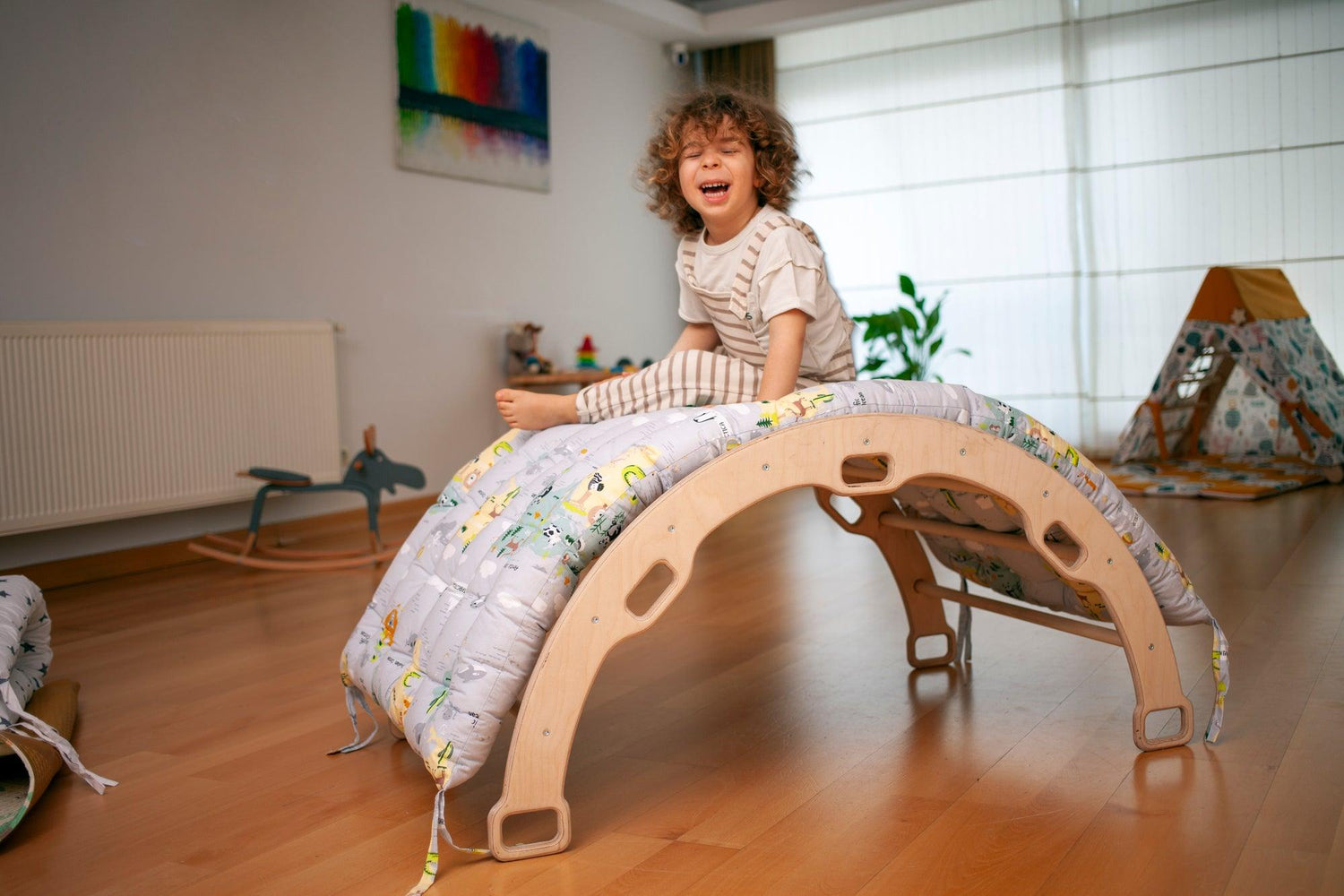 Red Oceanus climbing arch with map pattern pillow, a colorful furniture piece designed for play and comfort.