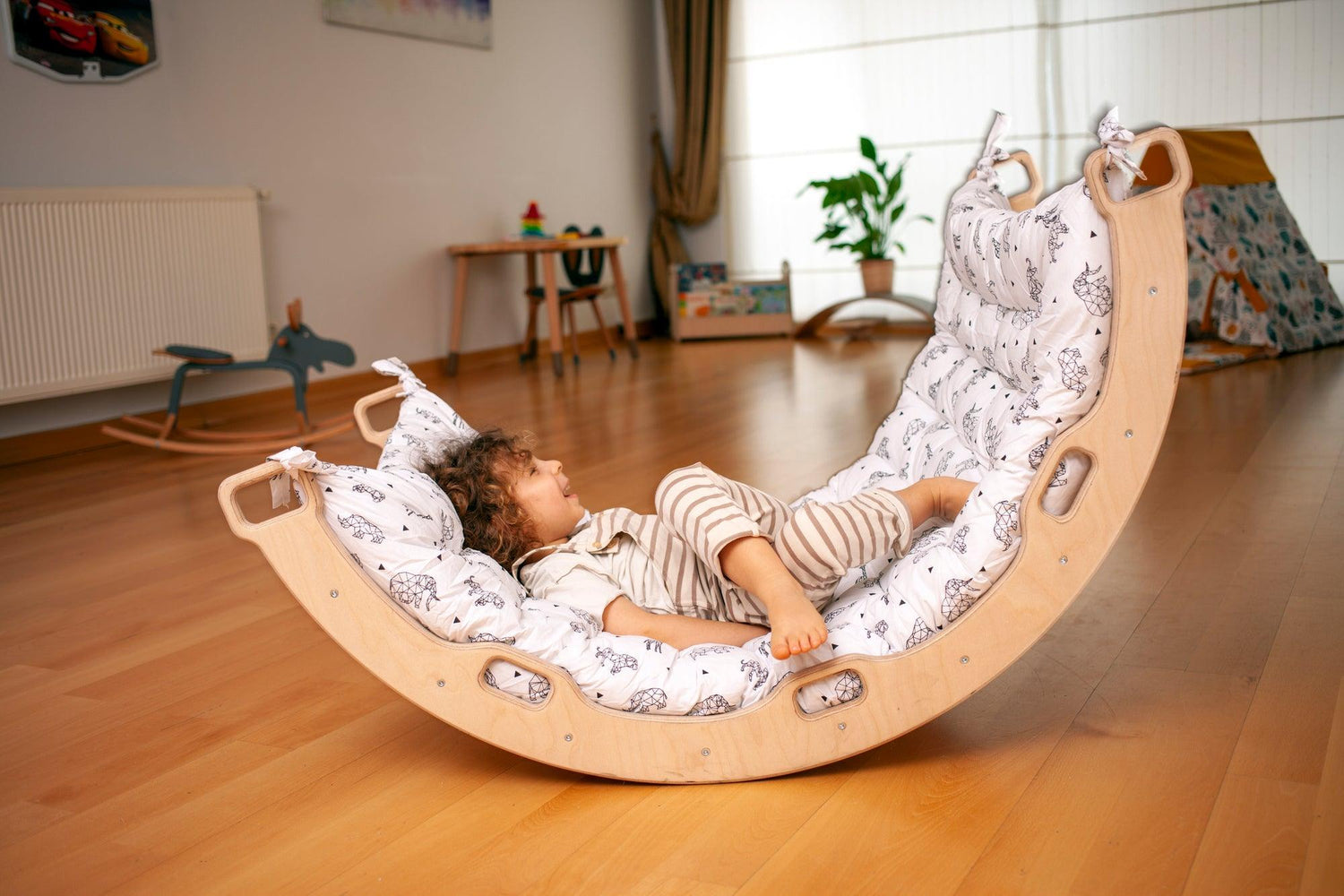 Red Oceanus climbing arch with origami pattern pillow, modern furniture piece featuring a curved design and decorative cushion.