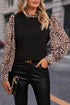 Black contrast leopard print lantern sleeve blouse by Carmine Juneberry, featuring a stylish design and flowing fabric.