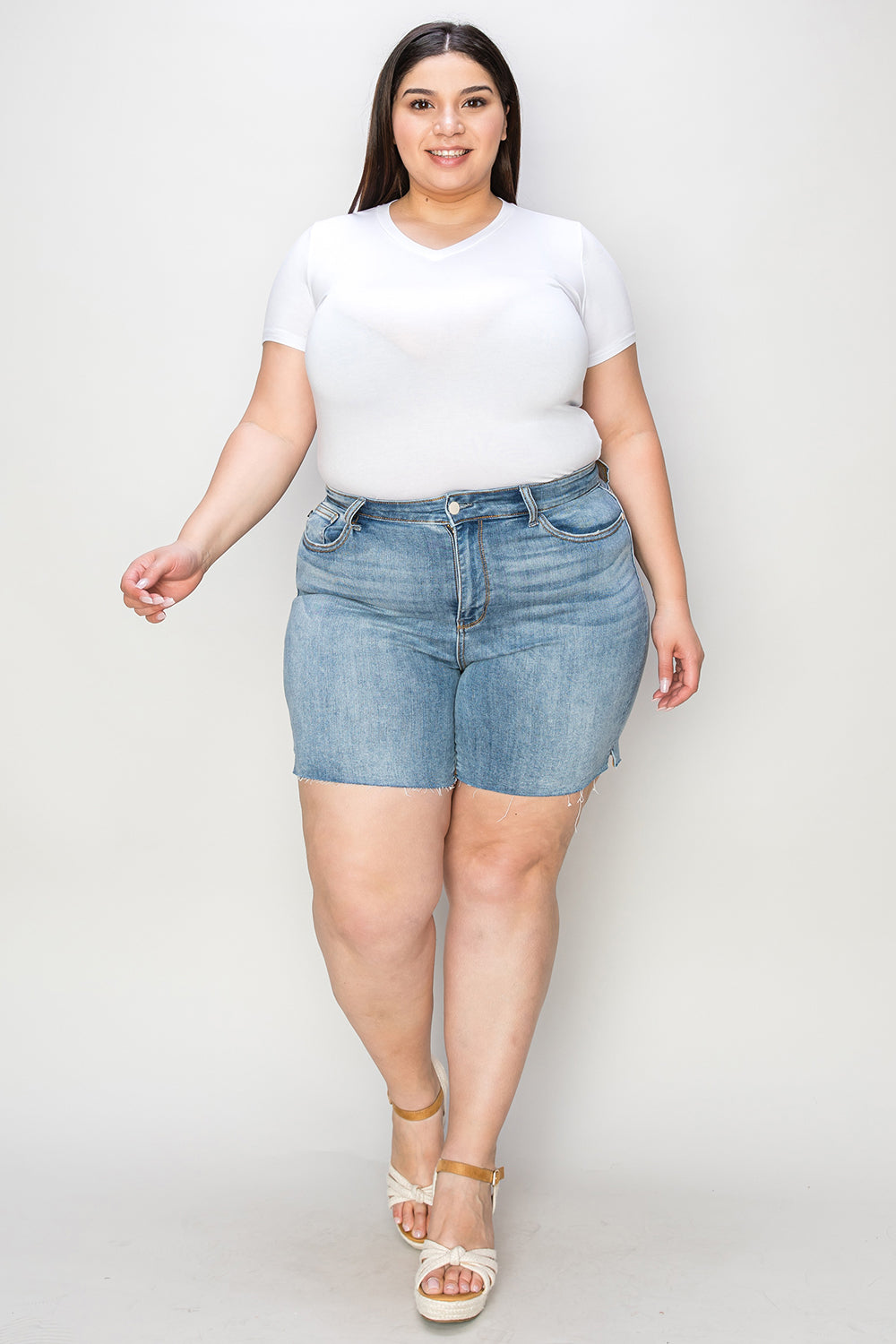 Judy Blue high waist raw hem denim shorts in a full size, displayed on a model, showcasing stylish cut and fit.