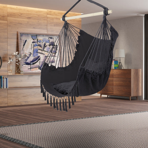 Gray LuneluX boho hanging chair by Carmine Juneberry with fringe and cushions, showcasing a cozy, stylish furniture piece.