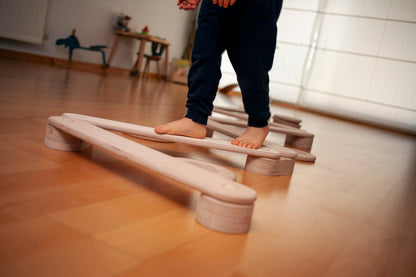 Circular wooden balance beam set by Red Oceanus, featuring smooth, round wooden beams for indoor or outdoor balance exercises.
