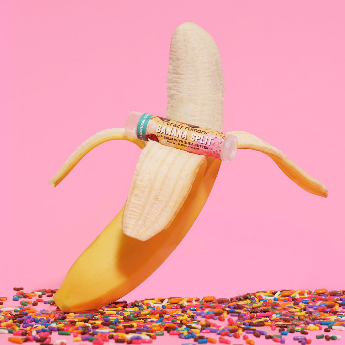 Orchid Nyx Banana Split Lip Balm in a makeup tube, displayed outdoors with fresh bananas and tropical-themed background.