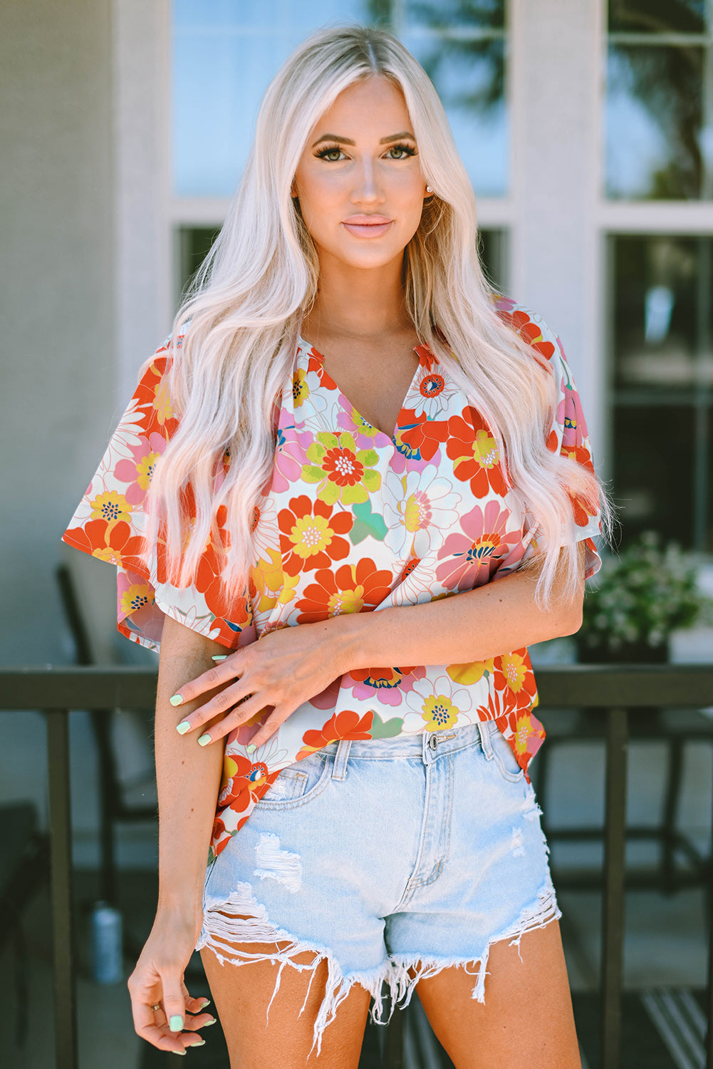 Orange abstract print V-neck blouse with half sleeves from Carmine Juneberry, stylish and comfortable for casual wear.