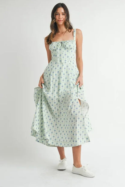 Pear Daisy MABLE floral print bustier back lace-up midi dress, shown hanging in a stylish home setting.