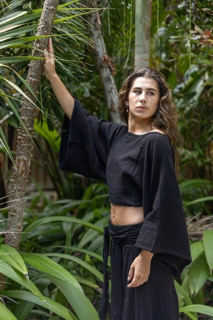 Black cotton Bloomara Top by Salmon Arrowwood with a waist tie, featuring a boho-inspired design and detailed fabric texture.