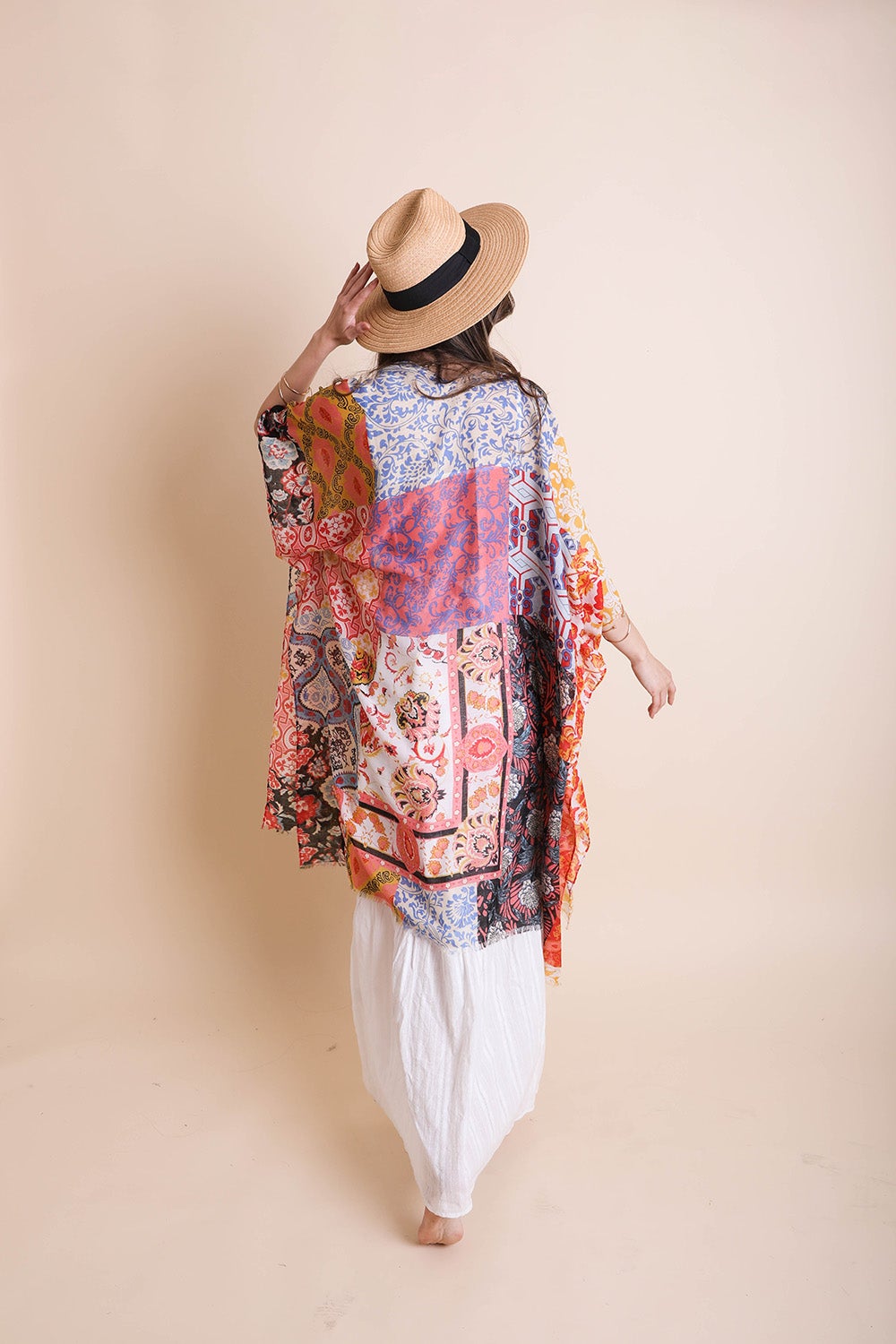 Colorful boho patchwork kimono by Periwinkle Aether featuring flowing fabric and intricate patchwork details, styled as a fashion accessory.