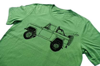 Pink Simba Bronco Surf Trip Leaf Green T-shirt displayed on a hanger with a surf-inspired graphic design.