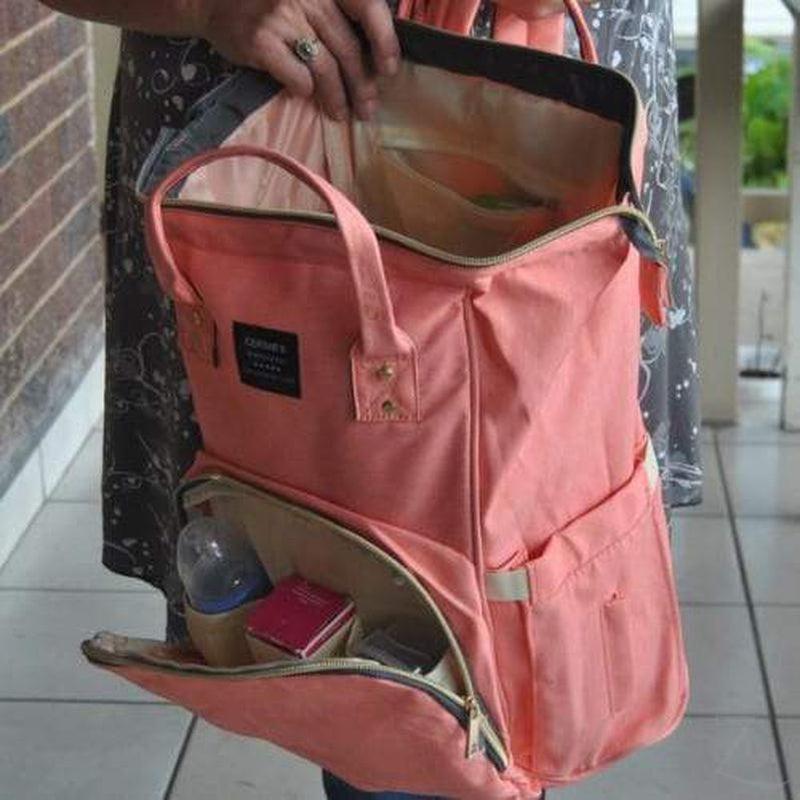 Raspberry Pallas peach denim backpack baby bag with adjustable straps and multiple pockets, ideal for parents on the go.