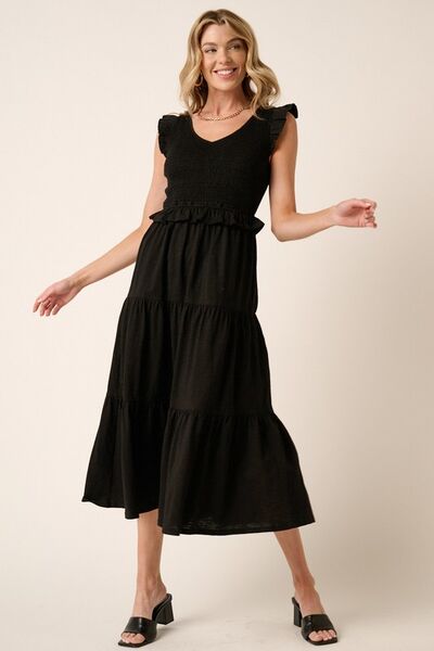Automotive Jade Icarus Mittoshop smocked ruffled tiered midi dress with floral pattern and ruffled neckline, displayed on a hanger.