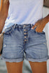 Distressed high rise button fly denim shorts by Harlequin Daisy, featuring a casual fit and distressed details.