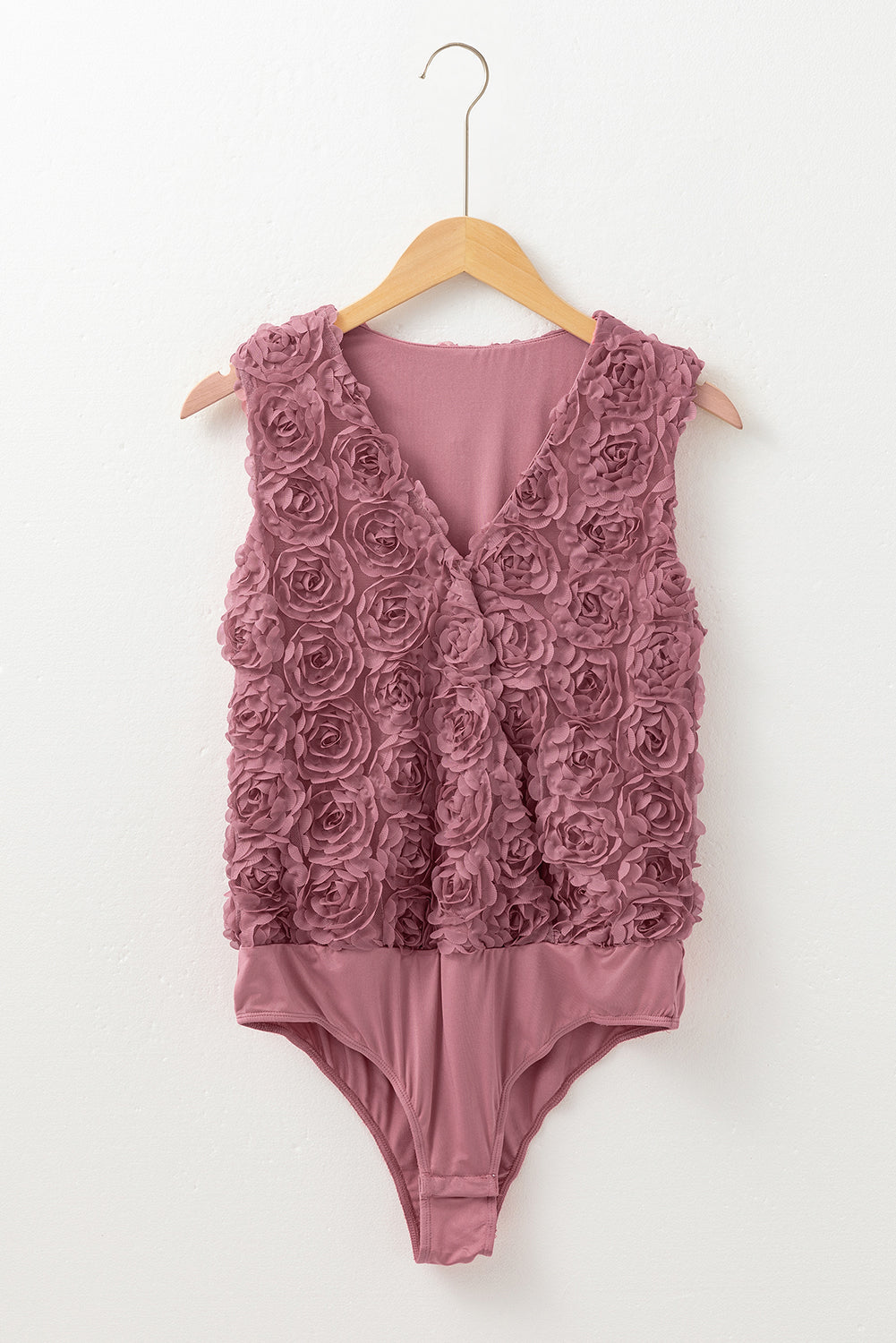 Floral textured v-neck sleeveless bodysuit by Byzantium Bay, wrapped style with fitted silhouette and vibrant floral pattern.