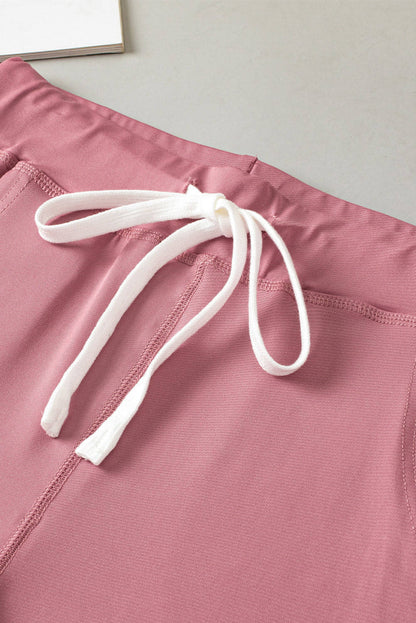 Pink drawstring waist joggers with pockets from Carmine Juneberry activewear, comfortable and stylish for workouts or casual wear.