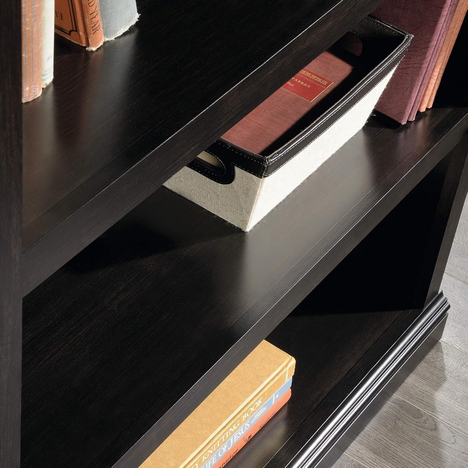Three-tier wooden bookshelf in estate black by Peach Maple with adjustable shelves, showcasing a modern furniture design.
