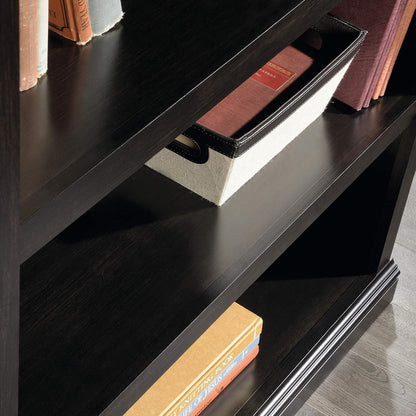 Three-tier wooden bookshelf in estate black by Peach Maple with adjustable shelves, showcasing a modern furniture design.