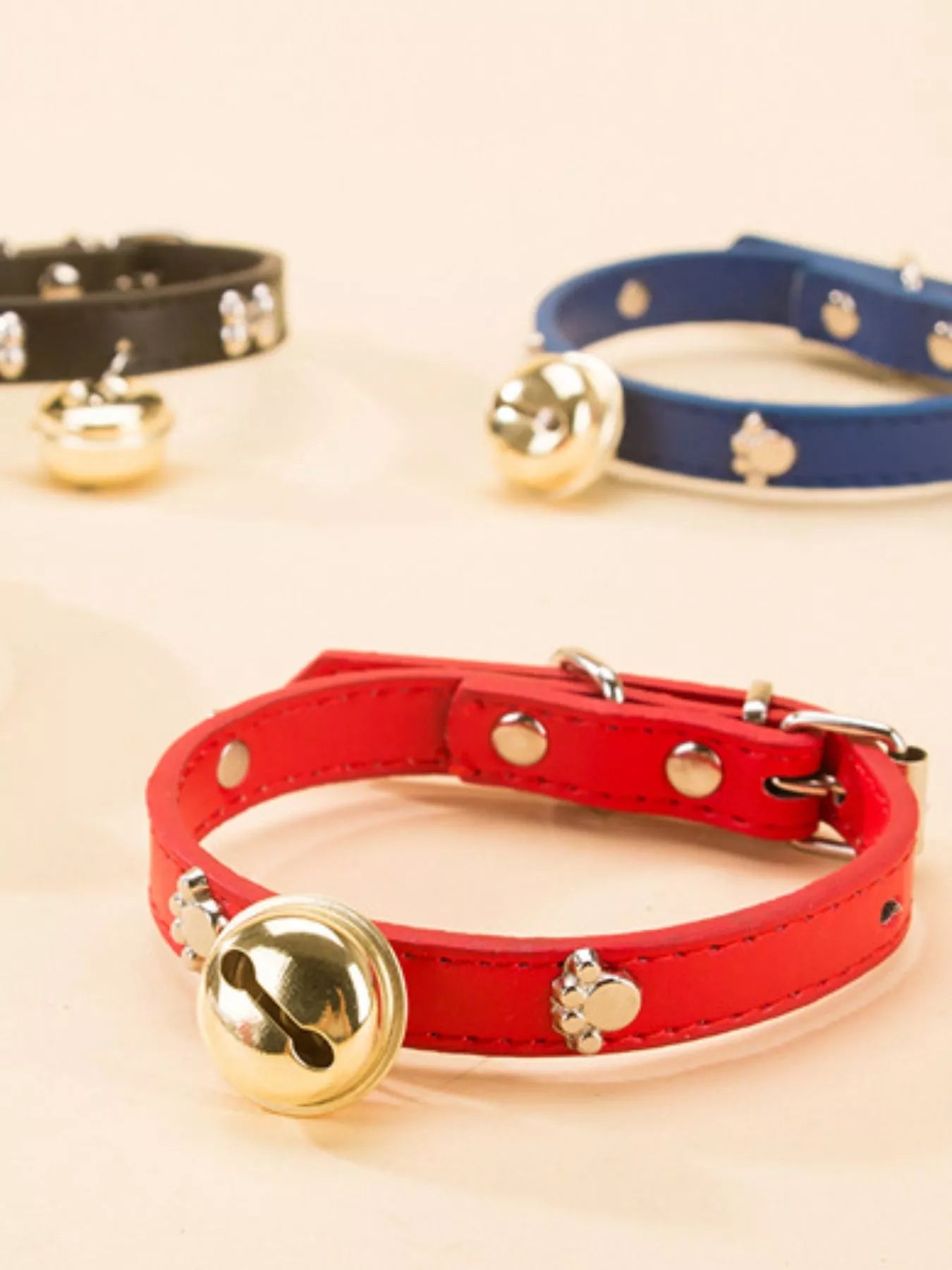 Leather pet collar with bell from Pear Daisy, featuring durable brown leather and a small metal bell for pets.