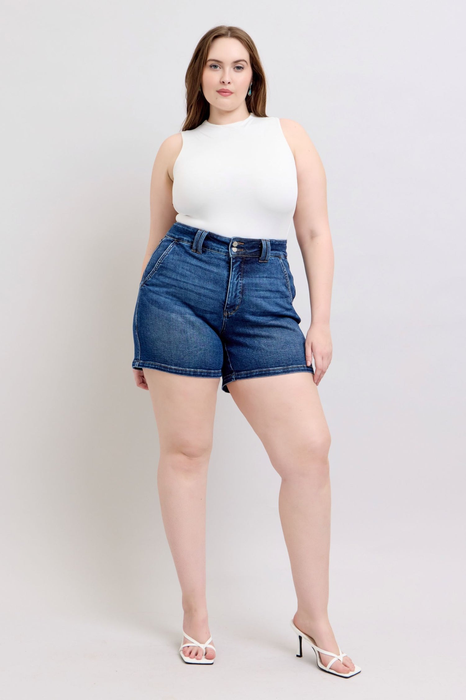 Judy Blue plus size denim shorts with double button waistband, featuring classic blue denim and frayed hem detail.