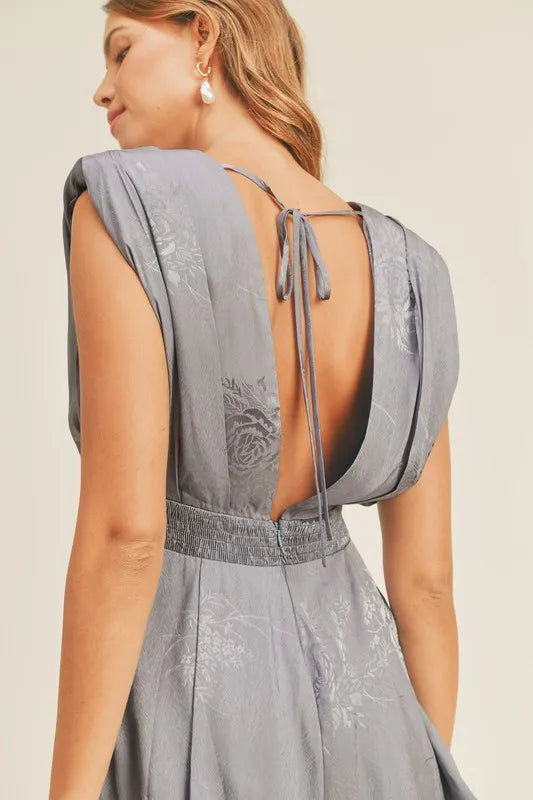 Pear Daisy MABLE draped romper with pleated shoulder pad detail, shown in a stylish home &amp; garden setting.
