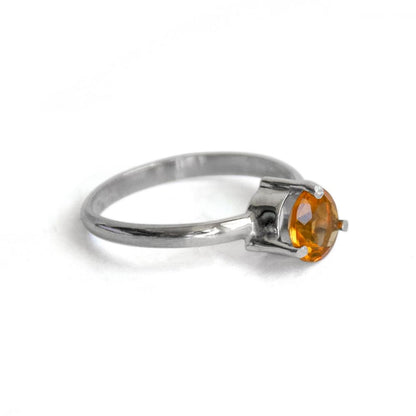 Sterling silver solitaire citrine ring with three prongs, featuring a vibrant yellow gemstone in an elegant jewelry design.