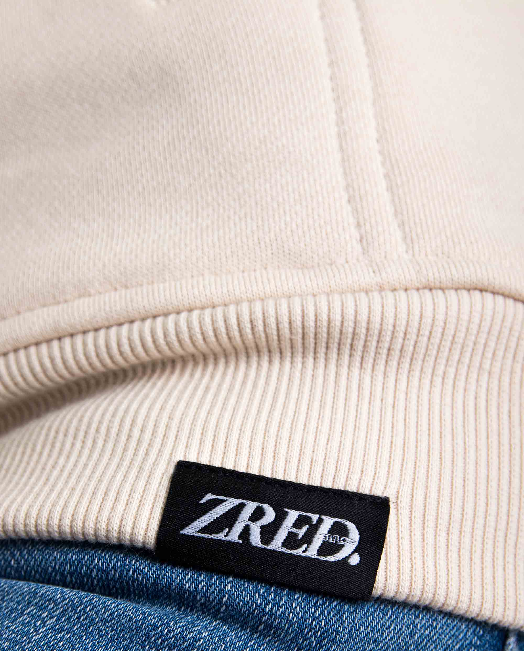 Close-up of the Pear Juniper HIGH STD hoodie in sand color, showcasing the soft fabric and hood detail.