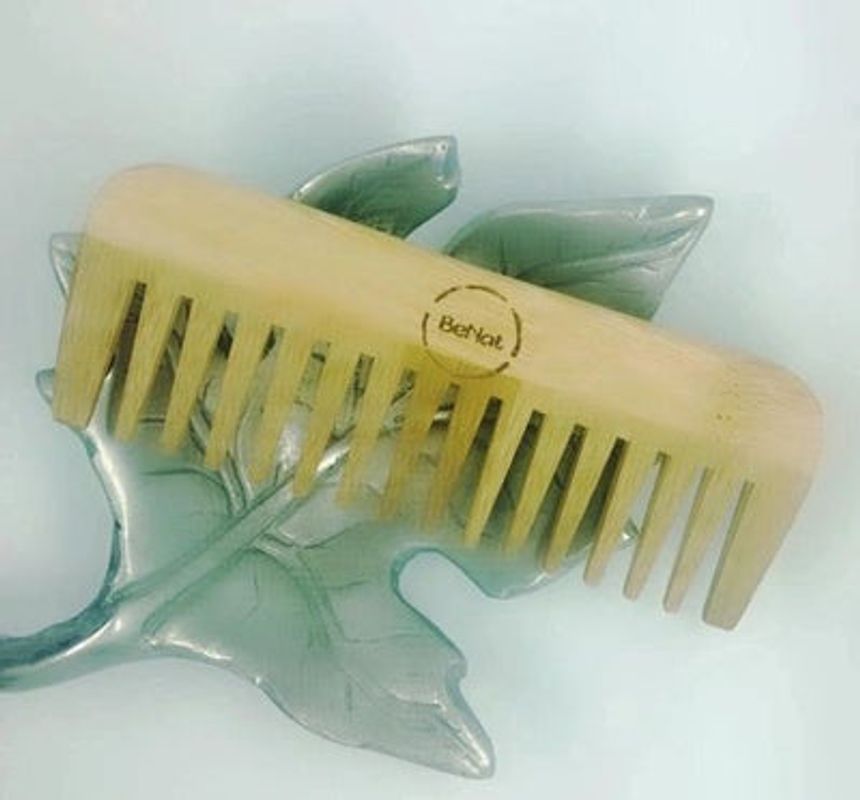 All-natural bamboo hair comb from Violet Atlas, featuring smooth teeth and eco-friendly design for gentle hair detangling.