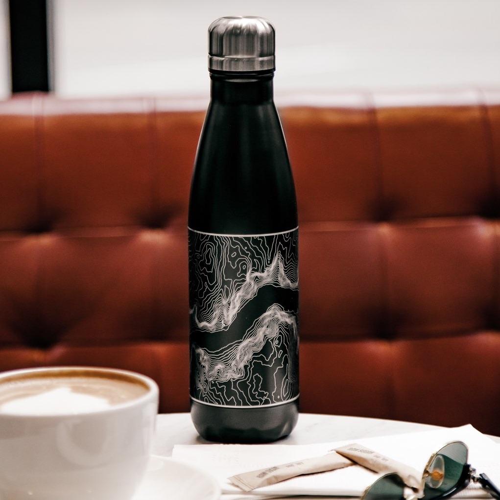 Cyan Castor Cormorant Lake Manitoba insulated bottle in matte black with a detailed map design, houseware item for beverages.