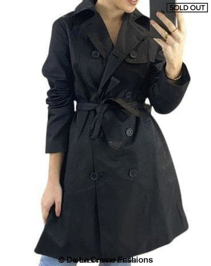 Black cotton blend belted trench coat by Rose Eleusis, shown on a model, featuring classic double-breasted design and waist belt.