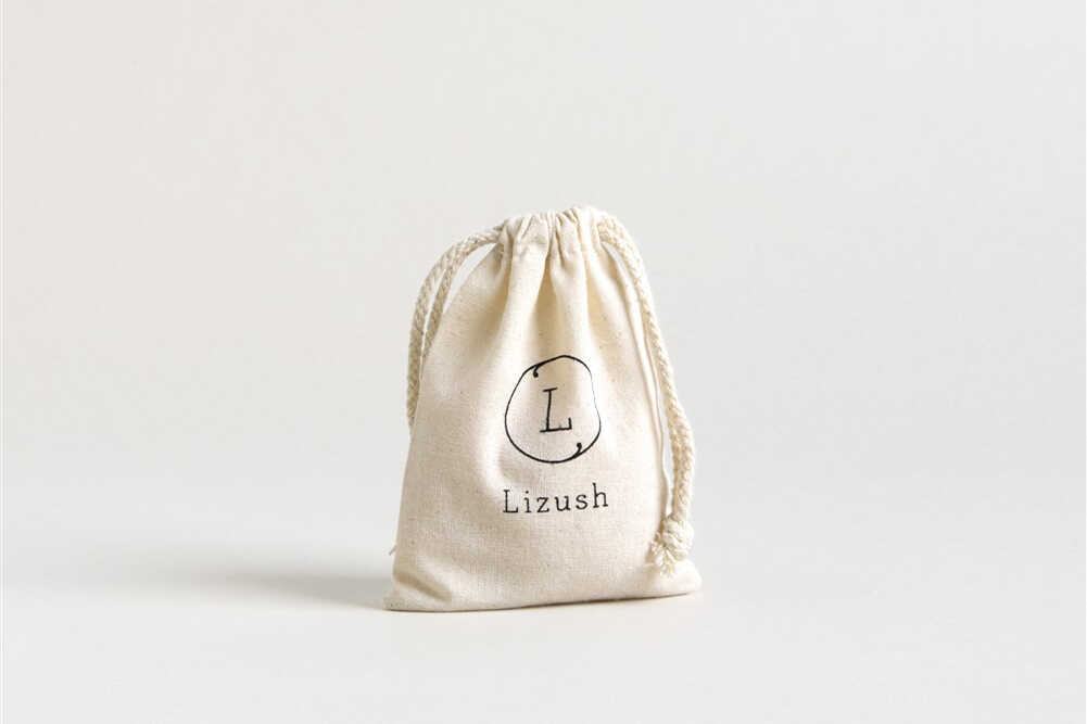 Lavender body oil in a cotton bag with DC-Lizush logo, natural moisturizing beauty product for soft, hydrated skin.