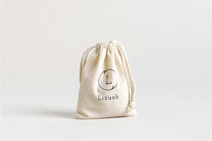 Lavender body oil in a cotton bag with DC-Lizush logo, natural moisturizing beauty product for soft, hydrated skin.
