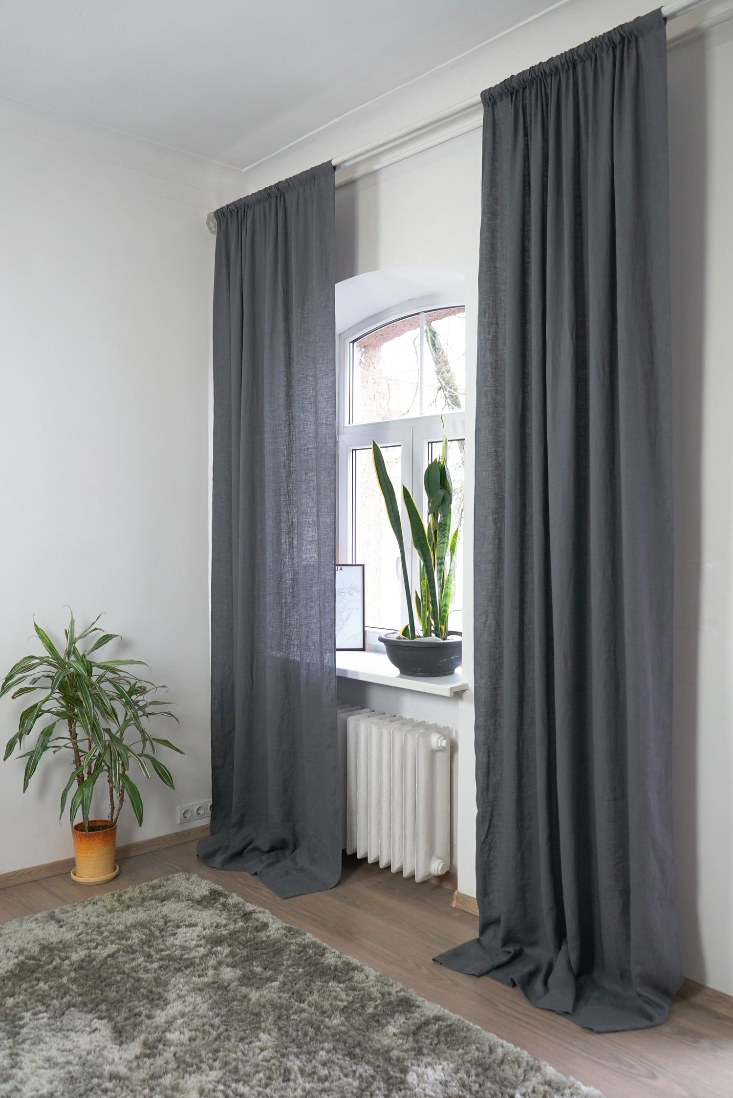 Grey linen curtain with rod pocket by Magenta Sugarplum hanging on a window, showcasing elegant home decor.
