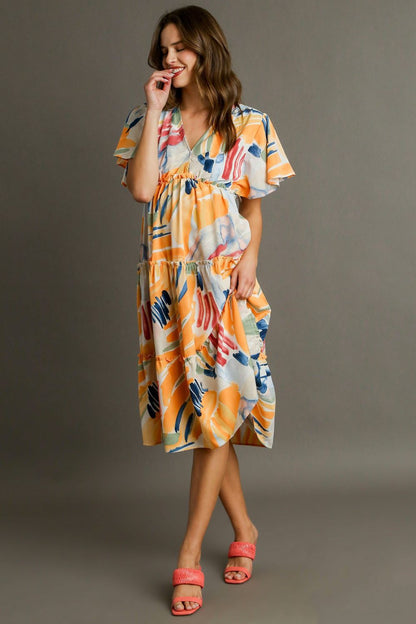 Colorful abstract print Umgee flutter sleeve frill tiered midi dress, showcasing its layered design and flowing fabric.