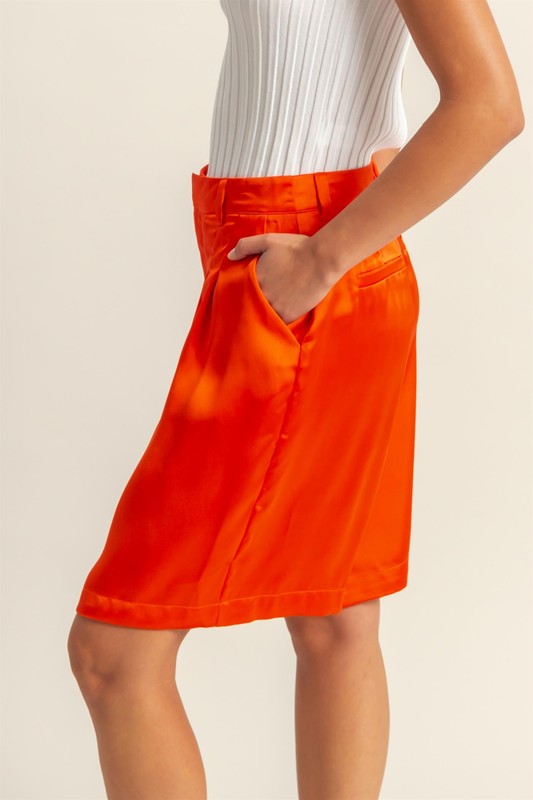 Satin high-waist pleated shorts from Jade Icarus, featuring a stylish automotive-inspired design with a glossy finish.