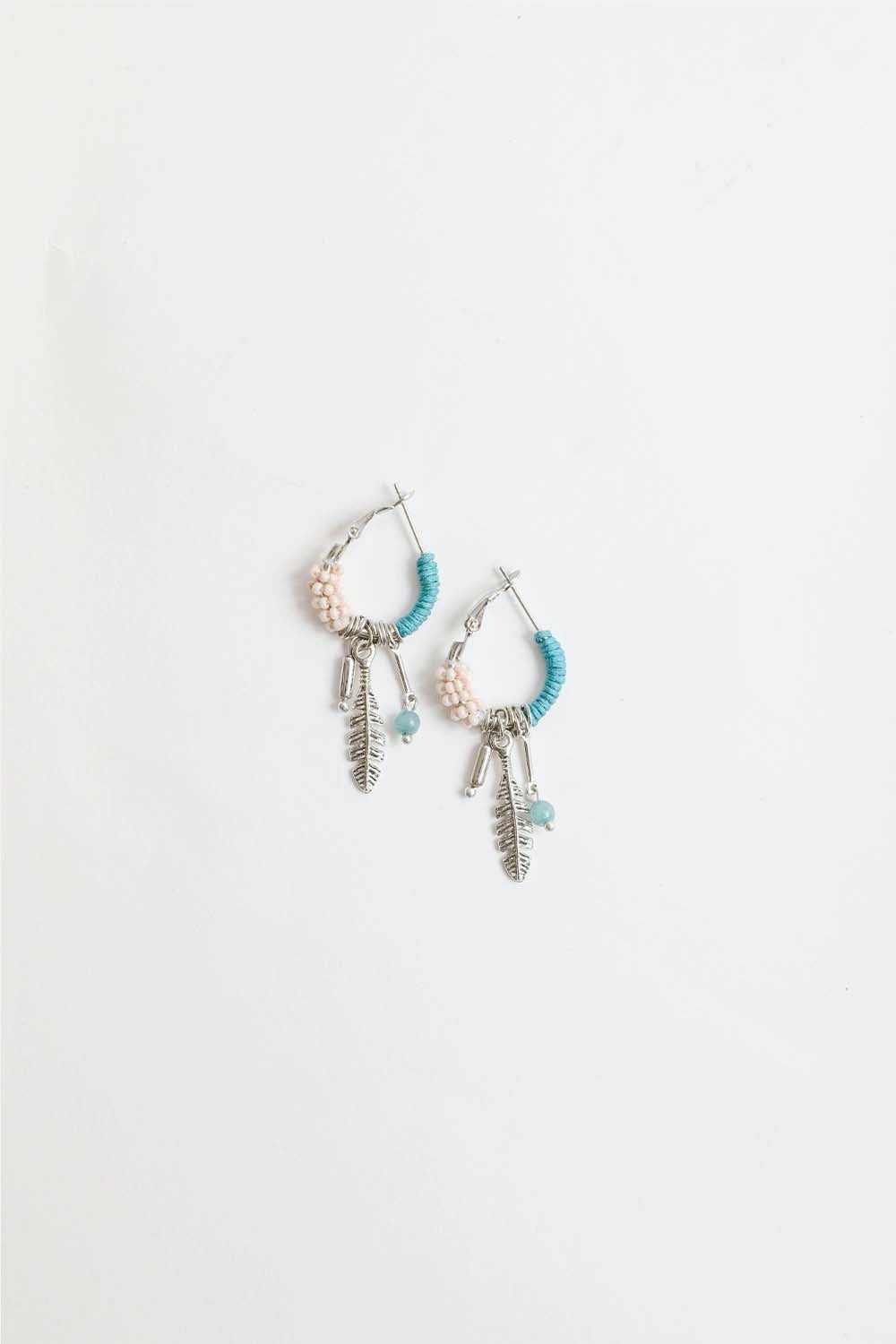 Dainty feather hoop earrings by Periwinkle Aether with delicate feather fringe, stylish accessories for a subtle, elegant look.