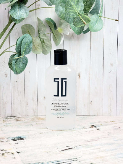 Sky Blue Lucy eucalyptus and white tea hand sanitizer bottle with pump, in a bathroom setting, emphasizing natural ingredients and clean design.