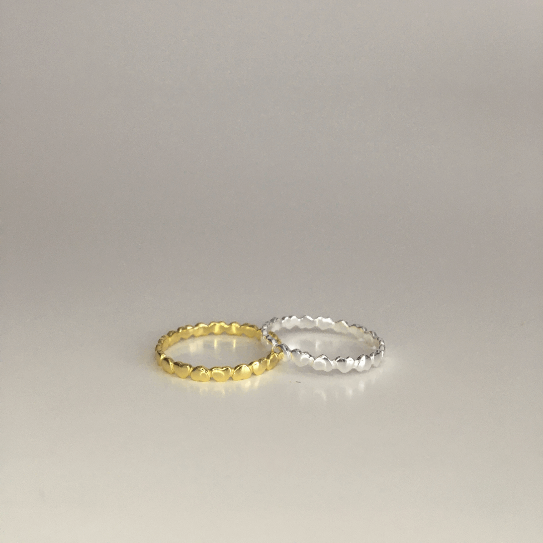 Cerise Poppy Circle of Love ring featuring a delicate gold band and a heart-shaped charm, elegant jewelry for special occasions.
