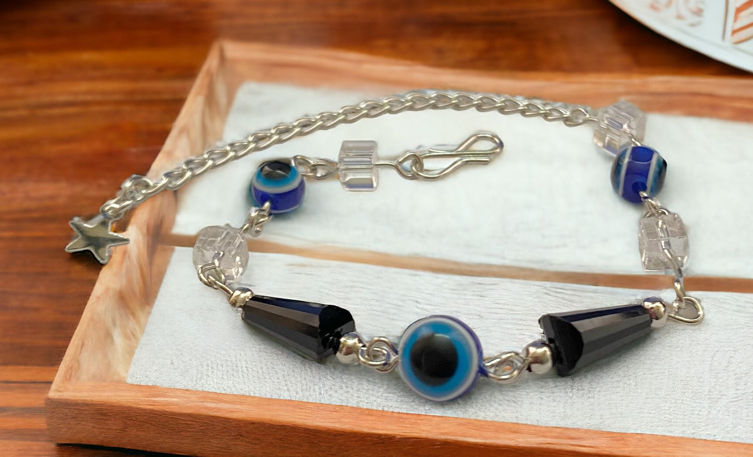 Gray Poseidon Fortune’s Shield Evil Eye Bracelet featuring a silver-tone charm and blue bead accents, designed for jewelry and protection.