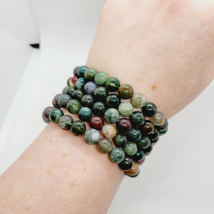 Colorful agate stone bracelets by Olive Coeus featuring semi-precious stones and Reiki healing properties, displayed on a neutral background.