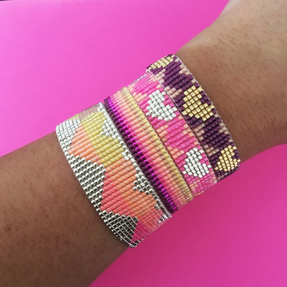 Colorful Rainbow Heart Bracelets by Yellow Athena featuring vibrant rainbow beads and heart-shaped charms on elastic bands.