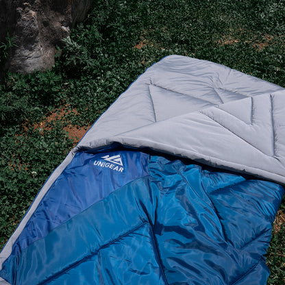 Indigo Eurybia Camfy 50 sleeping bag laid out outdoors, showing its compact, insulated design for camping and outdoor adventures.